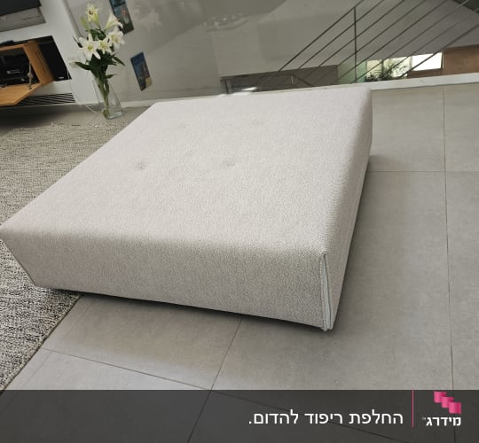 הדום מרובע מרופד בבד ארוג בהיר בסלון מודרני